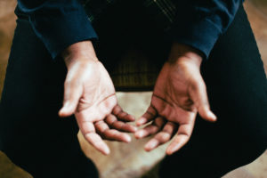 person looking down at their hands - catholic rehab