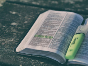 Holy Bible open with green highlighter between pages - catholic drug program