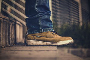 close up of tan leather sneakers standing on concrete steps -