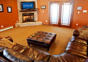living room with tv, fireplace, and brown leather sectional