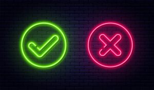 black brick background with neon signs: green check mark and red x - addictive personality